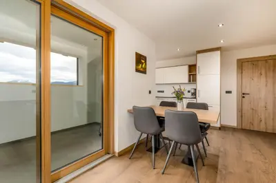 a kitchen and dining room with a table and chairs at Appartment Über die Wolken in Maranza