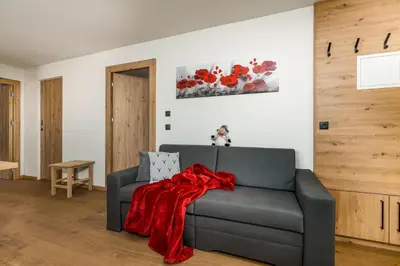 a kitchen with a wooden table and chairs at Appartment Über die Wolken in Maranza