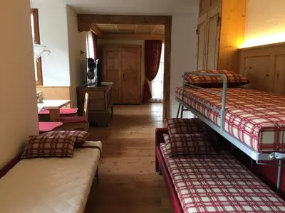 a room with three bunk beds and a hallway at Agritur el mas in Moena