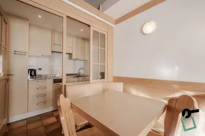 a small kitchen with a wooden table and chairs at HOTIDAY Apartment Collection - Santa Cristina in Santa Cristina in Val Gardena