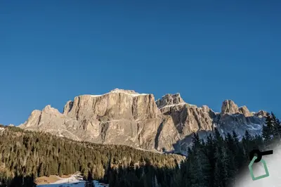 a person riding a snowboard in front of a mountain at HOTIDAY Apartment Collection - Santa Cristina in Santa Cristina in Val Gardena