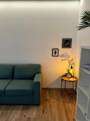 a living room with a blue couch and a table at Ferienwohnung Julian in Termeno