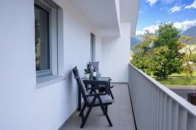 a table and chair on a balcony with a window at Apartment Weiss-Spitz in Vipiteno