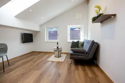 a living room with a chair and a television at Apartment Weiss-Spitz in Vipiteno