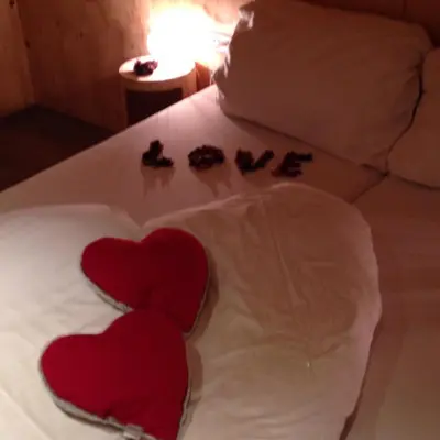 two red hearts on a bed with someones footprints at Apartments Resi in Rasùn di Sotto