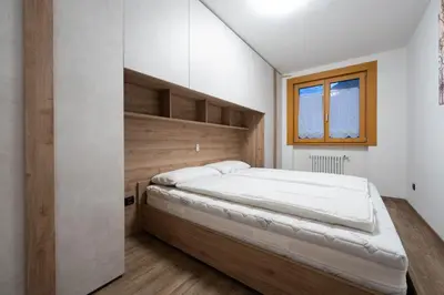 a bedroom with a large bed with a wooden headboard at Cesa Ricky in Canazei