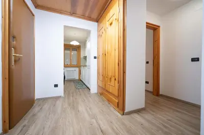 an empty hallway with a door and wooden floors at Cesa Ricky in Canazei
