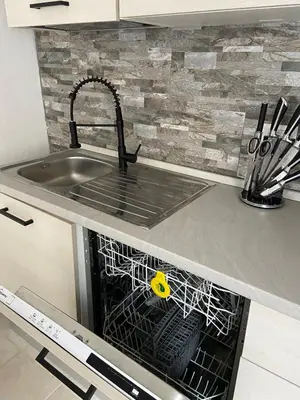 a sink in a kitchen with a dish drying rack at Luis Home in Laives