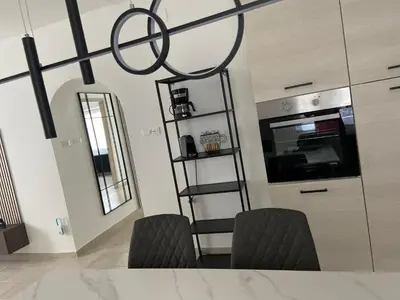 a kitchen with a table and two black chairs at Luis Home in Laives