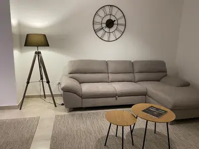 a living room with a couch and a clock on the wall at Luis Home in Laives