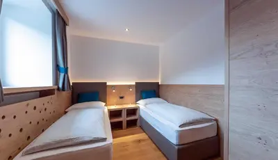 a small room with two beds and a window at Costadedoi in San Cassiano