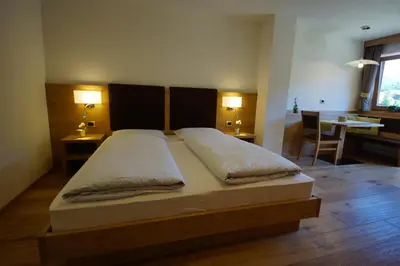 a bedroom with a large bed with two pillows at Costadedoi in San Cassiano