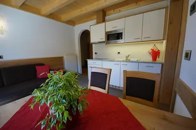 a kitchen and living room with a couch and a table at Costadedoi in San Cassiano