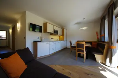 a kitchen and a living room with a couch and a table at Costadedoi in San Cassiano