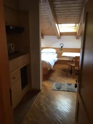 a bedroom with a bed and a table in a room at Bed & Breakfast Garnì Tobià in Campitello di Fassa
