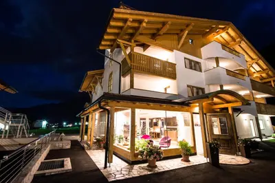 a building with a store front at night at Golden Park Resort in Campitello di Fassa