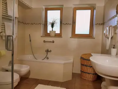 a bathroom with a tub and a toilet and a sink at Ferienbauernhof Masunerhof in Fiè