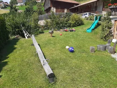 a yard with a playground with a slide and a ball at Ferienbauernhof Masunerhof in Fiè