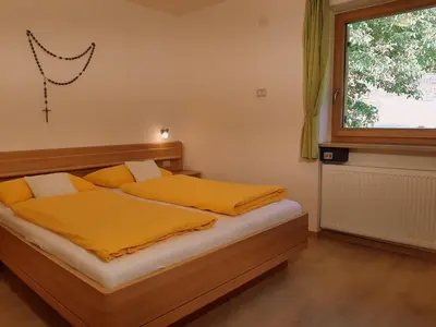 a bedroom with a bed with yellow sheets and a window at Ferienbauernhof Masunerhof in Fiè