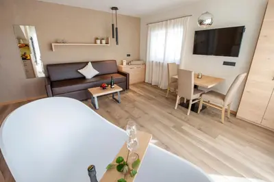 a living room with a couch and a table at Haus Gregori Modern & Central Stay in Vineyard with Rooftop & Served Breakfast in Caldaro
