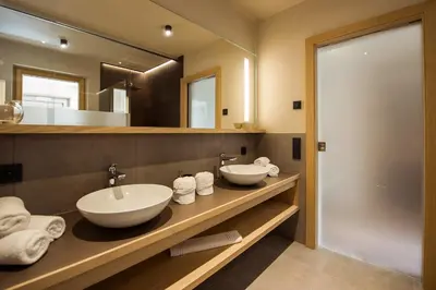 a bathroom with two sinks and a large mirror at Haus Gregori Modern & Central Stay in Vineyard with Rooftop & Served Breakfast in Caldaro