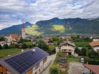 a view of a village with mountains in the background at Gösslturm in Lana