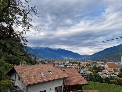 a town with a solar array on top of a town with a church at Gösslturm in Lana