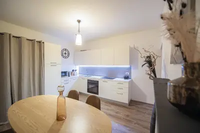 a kitchen with a wooden table and a dining room at Gösslturm in Lana