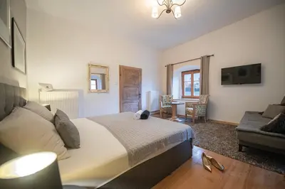a bedroom with a bed and a living room at Gösslturm in Lana