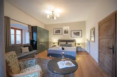 a bedroom with a bed and a living room at Gösslturm in Lana