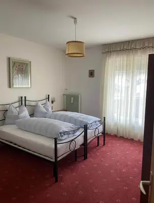 a bedroom with two beds and a red carpet at Mountainlodge Sellaronda in Canazei