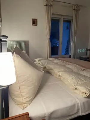 a bed with white sheets and pillows in a bedroom at Mountainlodge Sellaronda in Canazei