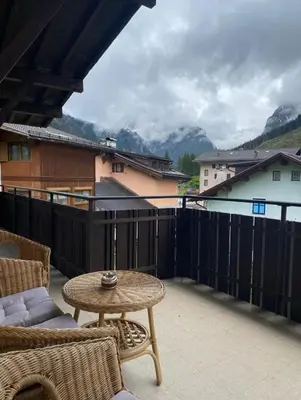 a patio with a table and chairs on a balcony at Mountainlodge Sellaronda in Canazei