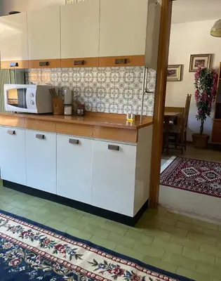 a kitchen with white cabinets and a microwave at Mountainlodge Sellaronda in Canazei