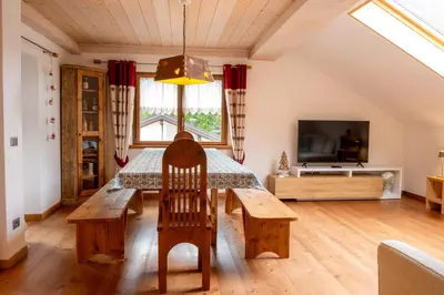 a living room with a table and a couch at Cèsa Cianacei Prestige in Canazei