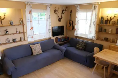 a living room with a blue couch and a table at Casa Bibi in Campitello di Fassa