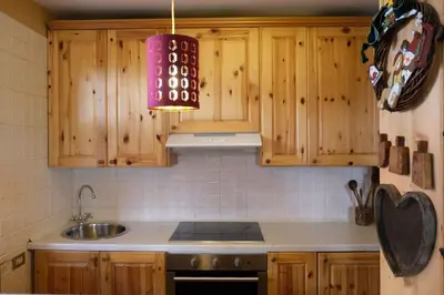 a kitchen with wooden cabinets and a sink at Casa Bibi in Campitello di Fassa