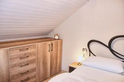 a bedroom with a bed and a wooden dresser at Cèsa Civetta in Canazei