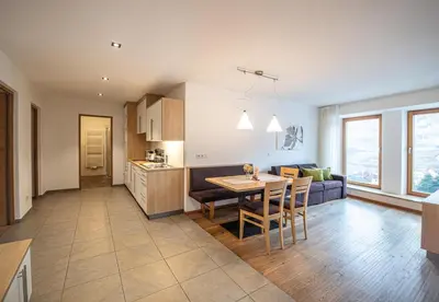 a kitchen and living room with a table and chairs at Ölackererhof in Bressanone