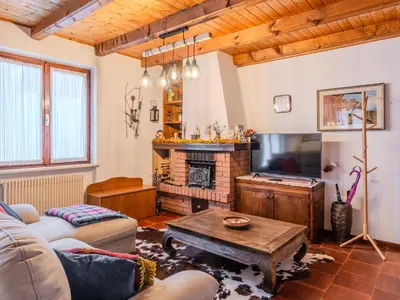 a living room with a fireplace and a tv at Apartment Ermeti by Interhome in Sfruz