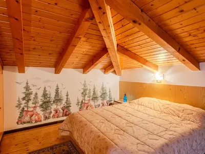 a bedroom with a bed in a room with wooden ceilings at Apartment Ermeti by Interhome in Sfruz