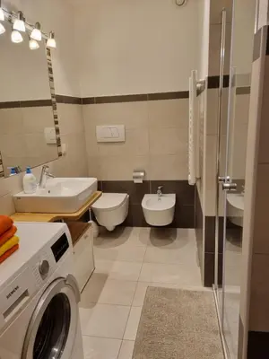 a bathroom with a washing machine and a sink at Ferienwohnungen Koflerhof in Castelrotto