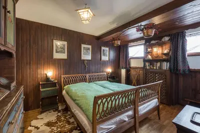 a bedroom with wooden walls and a bed with green sheets at Charming penthouse with breathtaking views in Cortina dʼAmpezzo