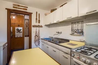 a kitchen with a sink and a stove at Charming penthouse with breathtaking views in Cortina dʼAmpezzo