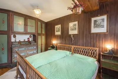 a bedroom with a bed and wooden walls at Charming penthouse with breathtaking views in Cortina dʼAmpezzo