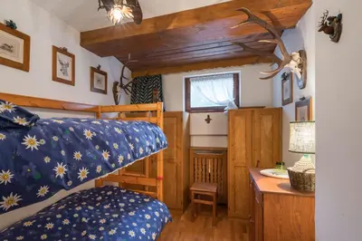 a bedroom with a bed and a desk in a room at Charming penthouse with breathtaking views in Cortina dʼAmpezzo