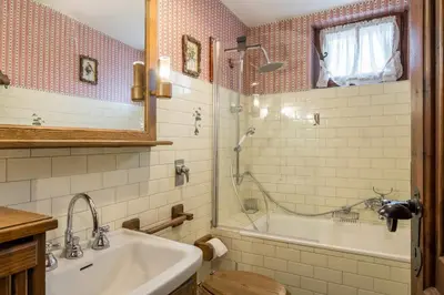 a bathroom with a tub and a sink and a shower at Charming penthouse with breathtaking views in Cortina dʼAmpezzo