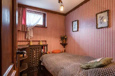 a bedroom with red wallpaper and a bed in it at Charming penthouse with breathtaking views in Cortina dʼAmpezzo