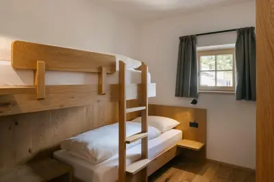 a bunk bed room with two bunk beds and a window at Schulmeisterhof in Kastelruth