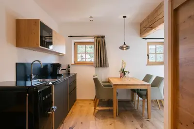a kitchen with a wooden table and a small dining room at Schulmeisterhof in Kastelruth